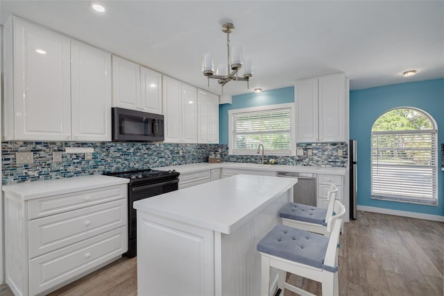 1913 Libby Ct, Holiday, FL 34690 - kitchen with black electric range, dishwasher, a chandelier, and healthy amount of natural light