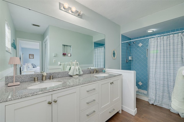1913 Libby Ct, Holiday, FL 34690 - ensuite bathroom with wood finished floors, double vanity, and tiled shower