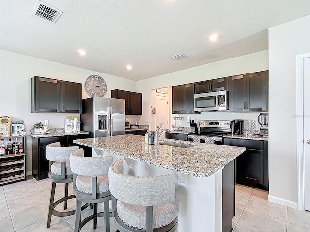 1508 Majestic Ln, Winter Haven, FL 33880 - kitchen with appliances with stainless steel finishes, a sink, a kitchen breakfast bar, light stone counters, and recessed lighting