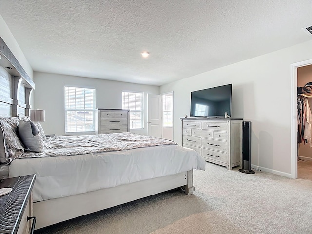 1508 Majestic Ln, Winter Haven, FL 33880 - bedroom featuring light carpet, baseboards, a textured ceiling, and a spacious closet