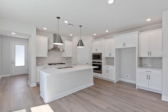 503 W Warren Ave Unit 1, Tampa, FL 33624 - kitchen with wall chimney exhaust hood, stainless steel appliances, a sink, backsplash, and recessed lighting