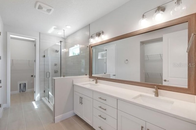 503 W Warren Ave Unit 1, Tampa, FL 33624 - bathroom with a shower stall, double vanity, a walk in closet, and tile patterned flooring