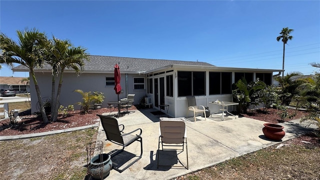 6405 Klaus Ct, Port Charlotte, FL 33981 - back of house featuring a sunroom, a patio area, a shingled roof, and stucco siding