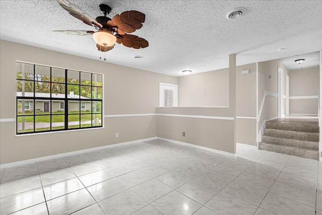 3331 Lime Tree Dr, Edgewater, FL 32141 - spare room with healthy amount of natural light, a ceiling fan, a textured ceiling, baseboards, and stairway
