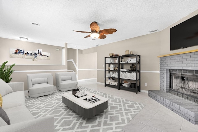 3331 Lime Tree Dr, Edgewater, FL 32141 - living area featuring ceiling fan, a fireplace, a textured ceiling, baseboards, and tile patterned flooring