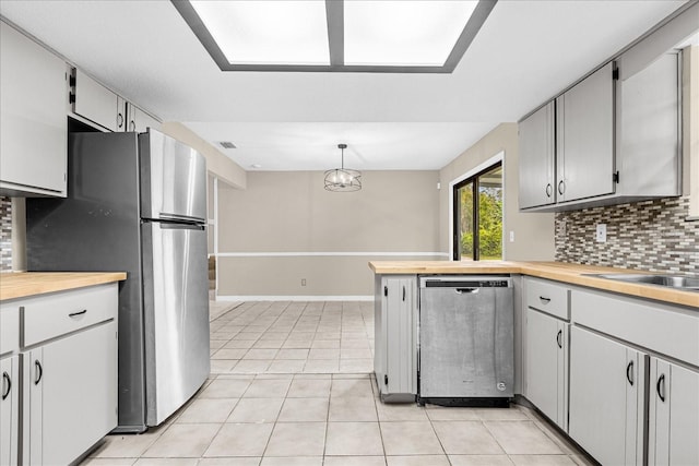 3331 Lime Tree Dr, Edgewater, FL 32141 - kitchen featuring stainless steel appliances, tasteful backsplash, light tile patterned floors, a peninsula, and wooden counters