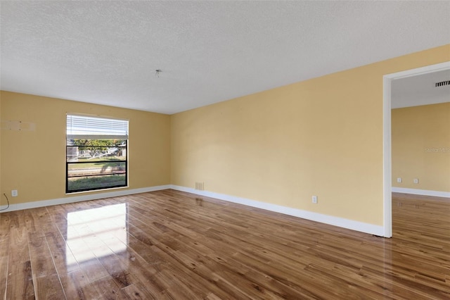 910 SE 23rd Pl, Cape Coral, FL 33990 - empty room with wood finished floors, a textured ceiling, and baseboards