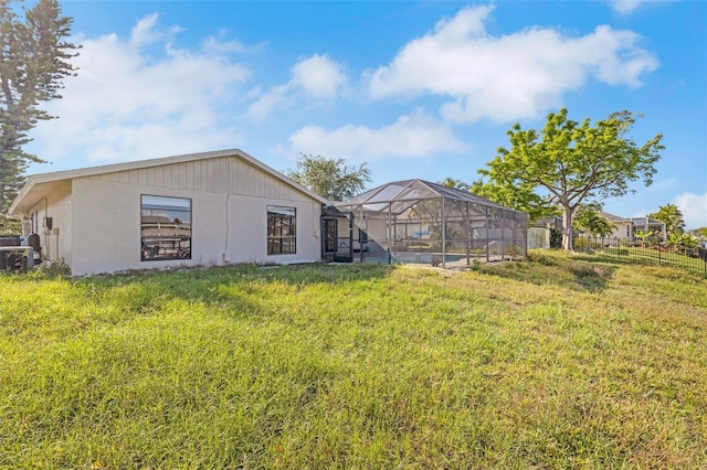 910 SE 23rd Pl, Cape Coral, FL 33990 - rear view of house with glass enclosure, stucco siding, and central AC unit