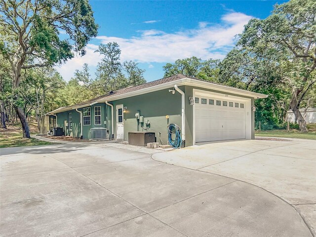 1199 E Mckinley St, Hernando, FL 34442 - view of front of house with stucco siding, central air condition unit, concrete driveway, and an attached garage