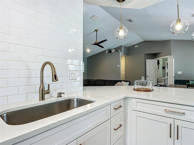 1199 E Mckinley St, Hernando, FL 34442 - kitchen with a sink, lofted ceiling, decorative light fixtures, white cabinets, and ceiling fan