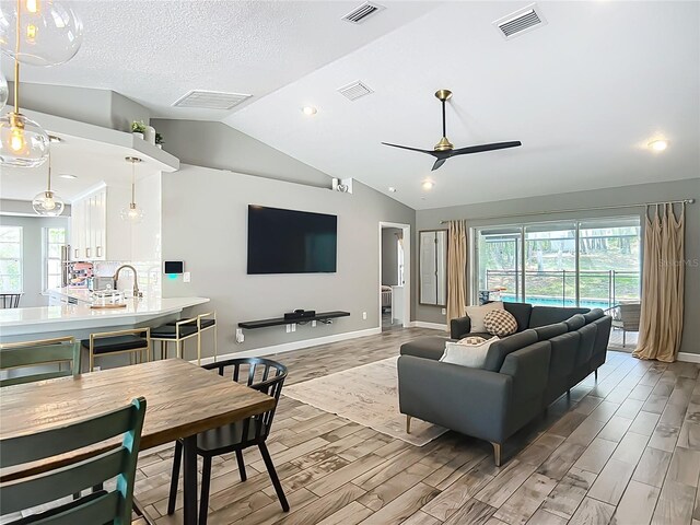 1199 E Mckinley St, Hernando, FL 34442 - living area with lofted ceiling, wood finished floors, baseboards, a ceiling fan, and a textured ceiling