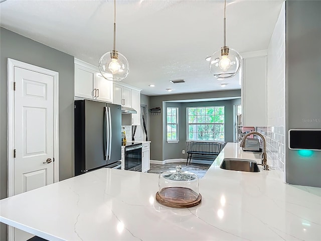 1199 E Mckinley St, Hernando, FL 34442 - kitchen featuring freestanding refrigerator, a sink, range with electric cooktop, under cabinet range hood, and white cabinetry