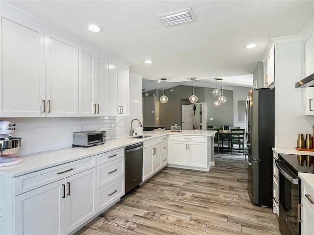 1199 E Mckinley St, Hernando, FL 34442 - kitchen featuring appliances with stainless steel finishes, a sink, a peninsula, white cabinets, and recessed lighting