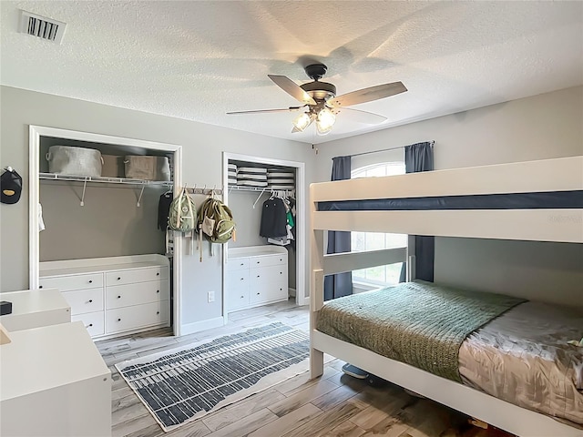 1199 E Mckinley St, Hernando, FL 34442 - bedroom with multiple closets, light wood-type flooring, a textured ceiling, and ceiling fan