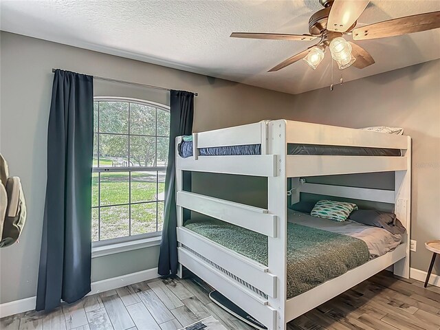1199 E Mckinley St, Hernando, FL 34442 - bedroom featuring baseboards, multiple windows, wood finished floors, a textured ceiling, and ceiling fan