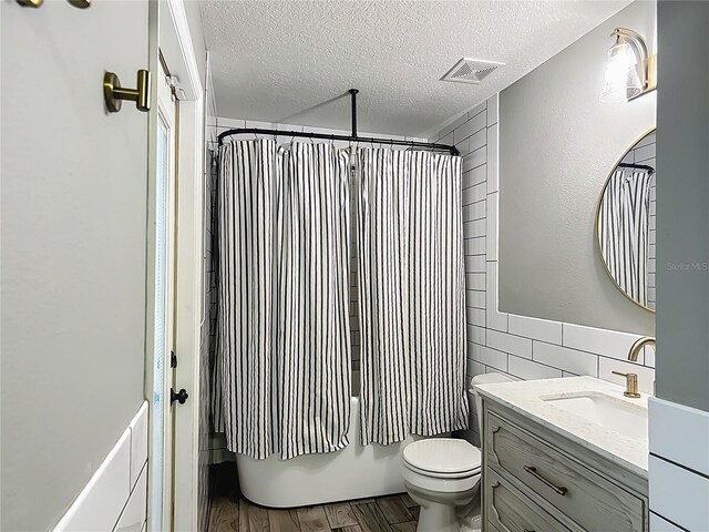 1199 E Mckinley St, Hernando, FL 34442 - bathroom featuring tile walls, a textured ceiling, vanity, toilet, and wood finished floors