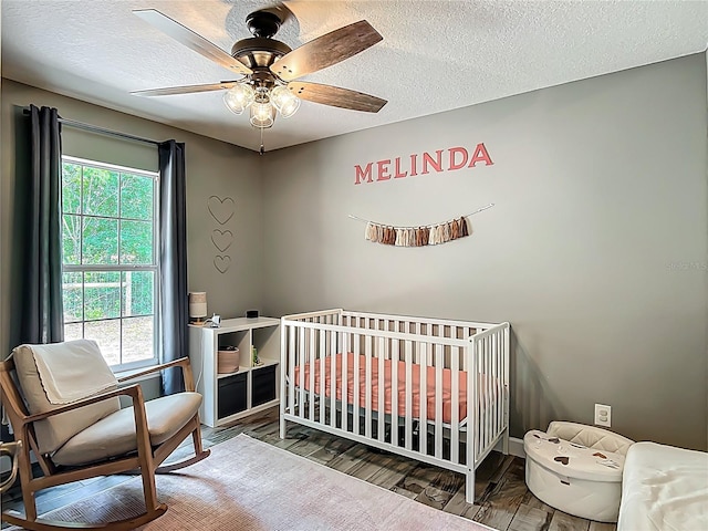1199 E Mckinley St, Hernando, FL 34442 - bedroom with ceiling fan, a textured ceiling, baseboards, a nursery area, and wood finished floors
