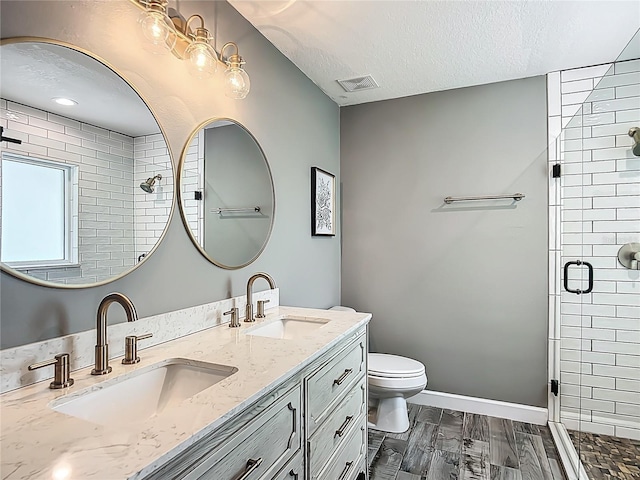 1199 E Mckinley St, Hernando, FL 34442 - full bathroom with a shower stall, double vanity, toilet, a textured ceiling, and baseboards