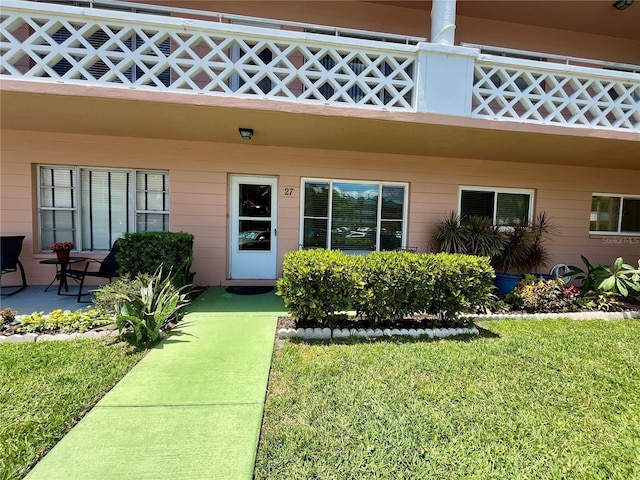 2457 Ecuadorian Way Unit 27, Clearwater, FL 33763 - view of exterior entry featuring a lawn
