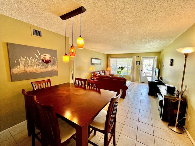 2457 Ecuadorian Way Unit 27, Clearwater, FL 33763 - dining space with a textured ceiling, light tile patterned floors, and baseboards
