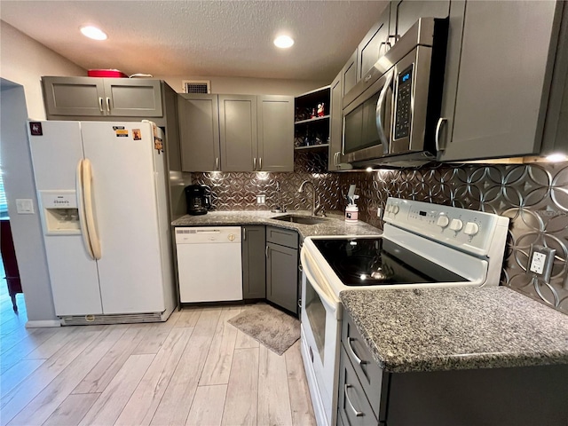 2457 Ecuadorian Way Unit 27, Clearwater, FL 33763 - kitchen with white appliances, light wood-style floors, open shelves, gray cabinetry, and a sink
