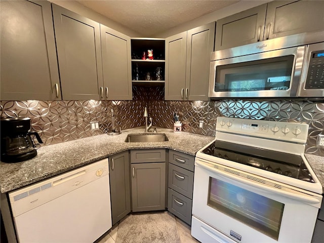 2457 Ecuadorian Way Unit 27, Clearwater, FL 33763 - kitchen featuring white appliances, a sink, gray cabinetry, decorative backsplash, and light stone countertops
