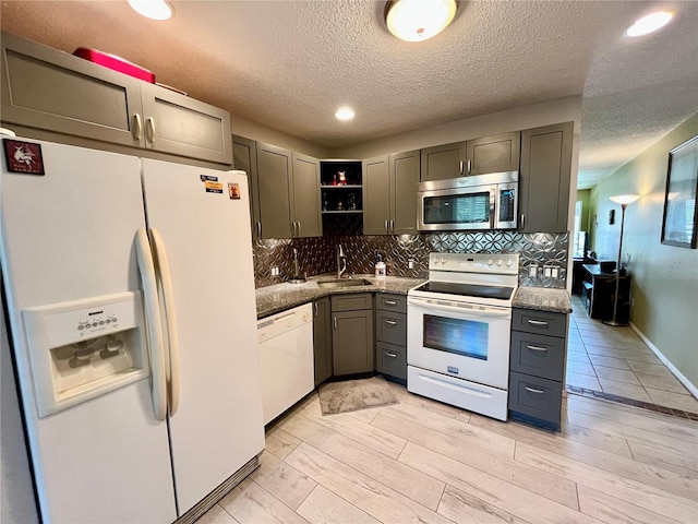 2457 Ecuadorian Way Unit 27, Clearwater, FL 33763 - kitchen with white appliances, a sink, open shelves, a textured ceiling, and tasteful backsplash