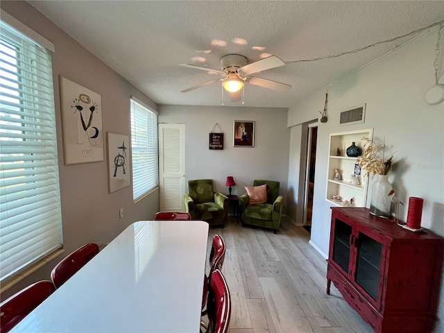 2457 Ecuadorian Way Unit 27, Clearwater, FL 33763 - dining area featuring light wood-style flooring, a ceiling fan, and a textured ceiling