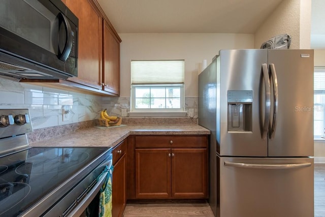 3642 Fantasy Way, Brooksville, FL 34604 - kitchen with stainless steel appliances, brown cabinets, light wood-style flooring, tasteful backsplash, and light countertops