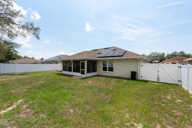 3642 Fantasy Way, Brooksville, FL 34604 - rear view of property with a gate, a sunroom, roof mounted solar panels, and stucco siding