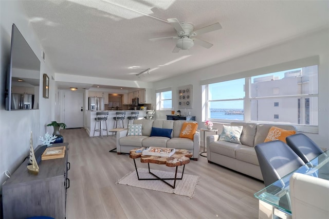 1270 Gulf Blvd Unit 1901, Clearwater Beach, FL 33767 - living room featuring a textured ceiling, a ceiling fan, and light wood-type flooring