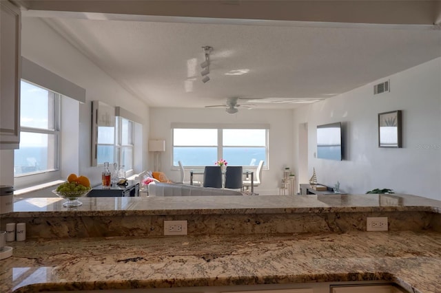 1270 Gulf Blvd Unit 1901, Clearwater Beach, FL 33767 - kitchen featuring a ceiling fan, open floor plan, and light stone counters