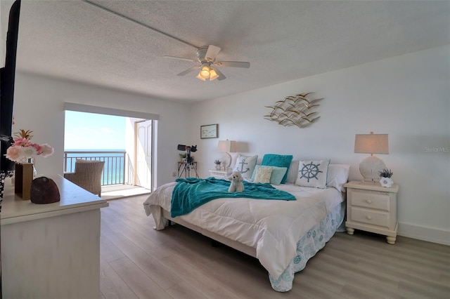1270 Gulf Blvd Unit 1901, Clearwater Beach, FL 33767 - bedroom with light wood-type flooring, access to outside, a textured ceiling, baseboards, and a ceiling fan