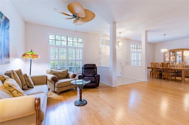 9908 Alafia River Ln, Gibsonton, FL 33534 - living room featuring a chandelier, a ceiling fan, light wood-style floors, and plenty of natural light