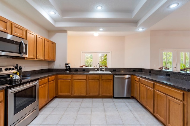 9908 Alafia River Ln, Gibsonton, FL 33534 - kitchen with appliances with stainless steel finishes, a sink, a raised ceiling, brown cabinetry, and recessed lighting