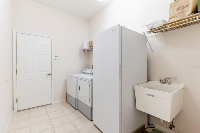 9908 Alafia River Ln, Gibsonton, FL 33534 - laundry area featuring washer and dryer, light tile patterned floors, and baseboards