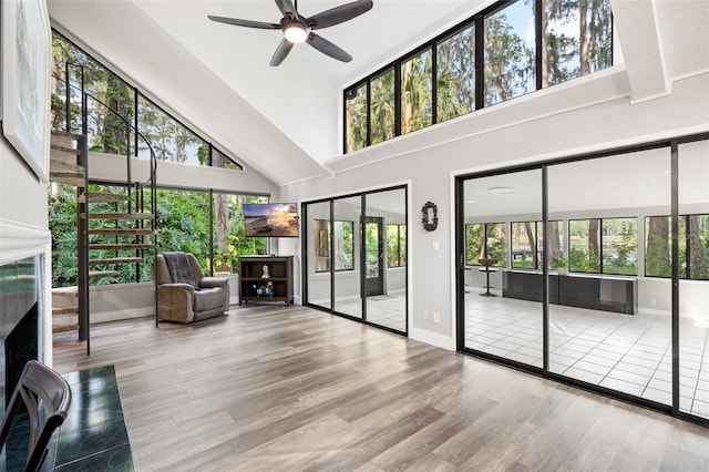 22004 Dupree Dr, Land O Lakes, FL 34639 - living area featuring a towering ceiling, wood finished floors, ceiling fan, baseboards, and a fireplace