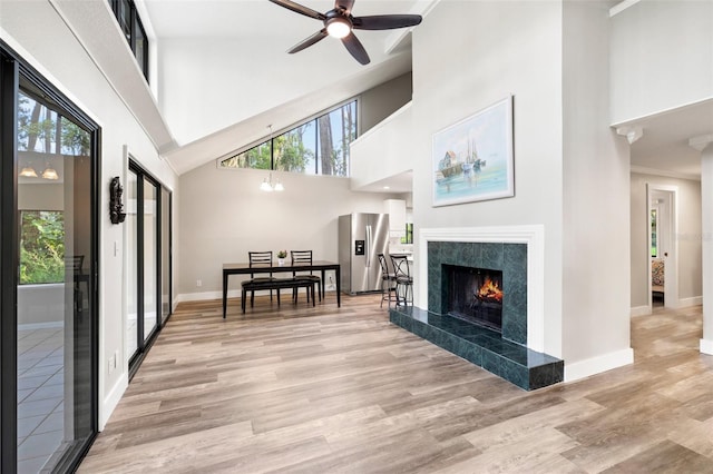 22004 Dupree Dr, Land O Lakes, FL 34639 - living room with a towering ceiling, plenty of natural light, a ceiling fan, light wood-style flooring, and a fireplace