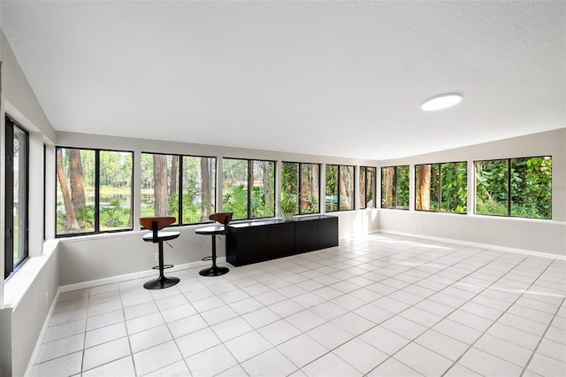 22004 Dupree Dr, Land O Lakes, FL 34639 - unfurnished sunroom with baseboards and tile patterned floors
