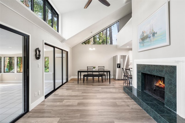 22004 Dupree Dr, Land O Lakes, FL 34639 - living area featuring a towering ceiling, ceiling fan, light wood-type flooring, baseboards, and a high end fireplace