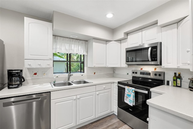 22004 Dupree Dr, Land O Lakes, FL 34639 - kitchen featuring stainless steel appliances, a sink, light countertops, white cabinetry, and recessed lighting
