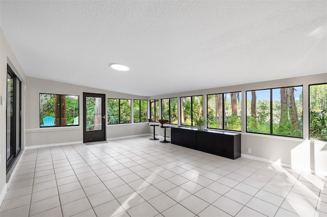 22004 Dupree Dr, Land O Lakes, FL 34639 - unfurnished sunroom with baseboards, tile patterned flooring, a textured ceiling, and lofted ceiling