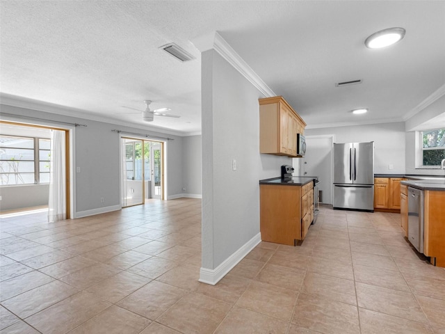 1701 38th St N, Saint Petersburg, FL 33713 - kitchen featuring appliances with stainless steel finishes, dark countertops, crown molding, a ceiling fan, and light tile patterned floors