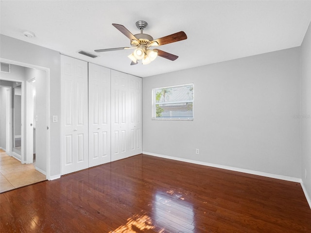 1701 38th St N, Saint Petersburg, FL 33713 - unfurnished bedroom with baseboards, wood finished floors, a closet, and a ceiling fan