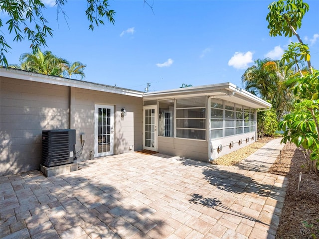 1701 38th St N, Saint Petersburg, FL 33713 - rear view of property featuring central AC, a sunroom, a patio, and concrete block siding