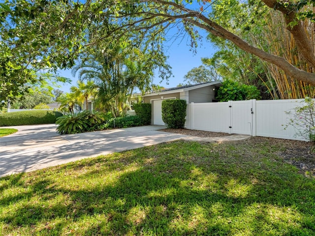 1701 38th St N, Saint Petersburg, FL 33713 - view of yard featuring a gate, driveway, and a garage