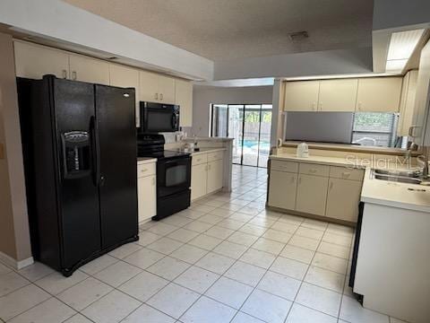 10811 Candlin Ct, Riverview, FL 33578 - kitchen featuring black appliances, a sink, light tile patterned flooring, light countertops, and cream cabinetry