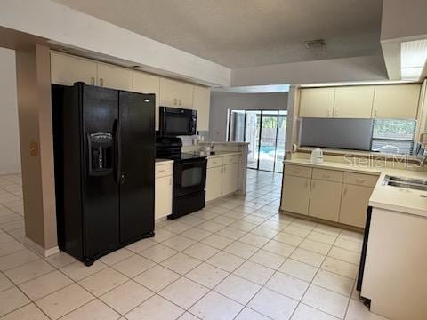 10811 Candlin Ct, Riverview, FL 33578 - kitchen featuring black appliances, light countertops, a sink, light tile patterned flooring, and cream cabinets