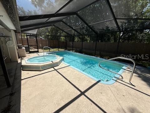 10811 Candlin Ct, Riverview, FL 33578 - view of swimming pool with a patio, a fenced backyard, glass enclosure, and a pool with connected hot tub