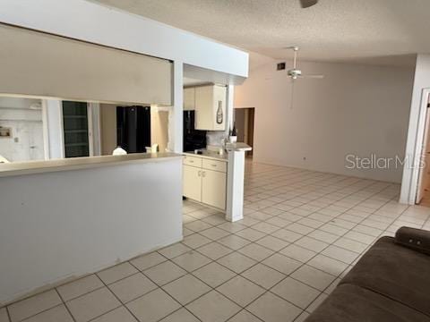 10811 Candlin Ct, Riverview, FL 33578 - kitchen with a ceiling fan, light countertops, lofted ceiling, white cabinets, and light tile patterned floors